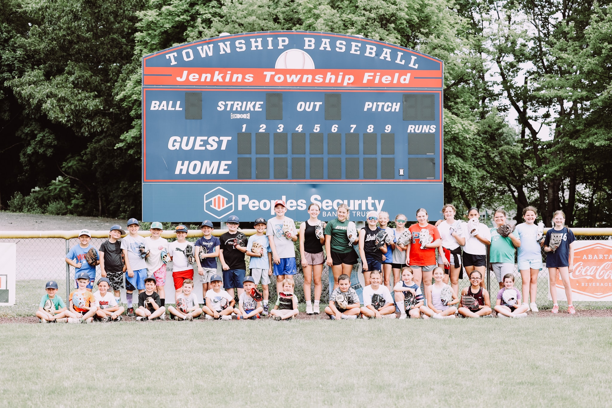 Softball coach working with youth athletes on training drill